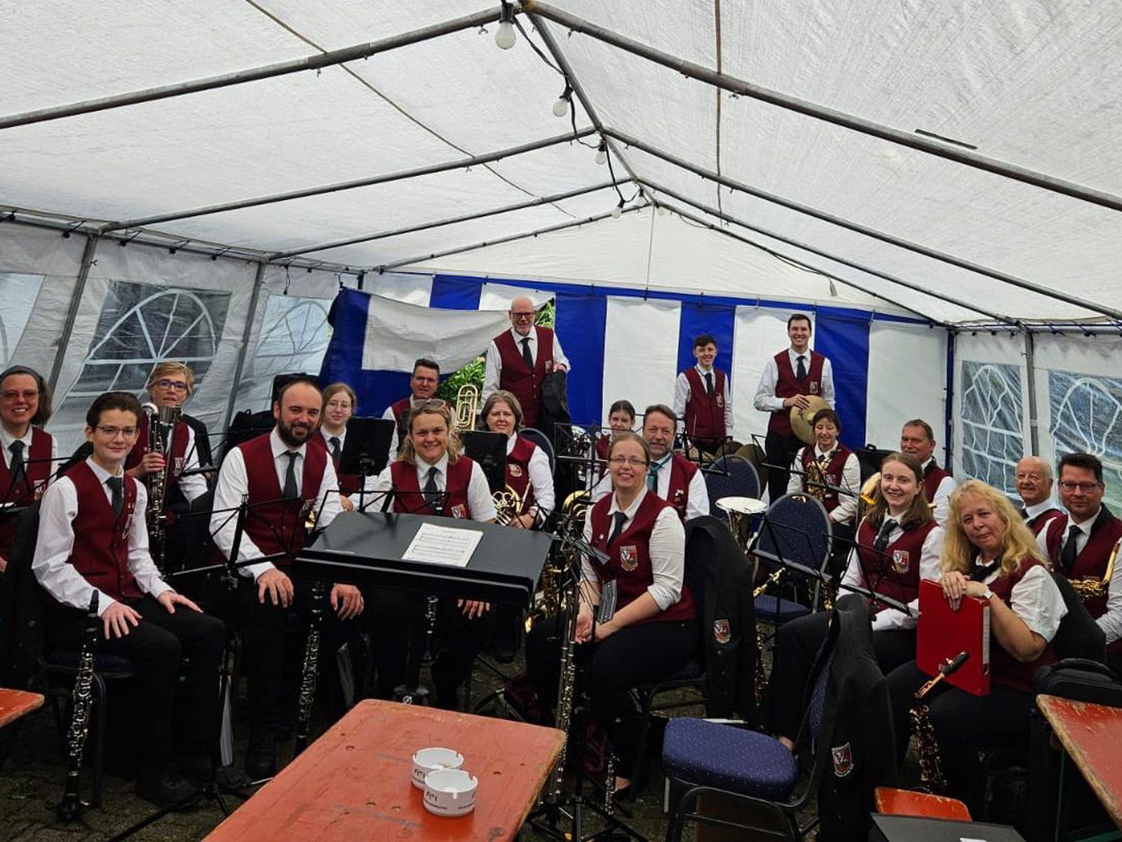 Gruppenbild der Stammkapelle in Uniform im blau-weißen Festzelt