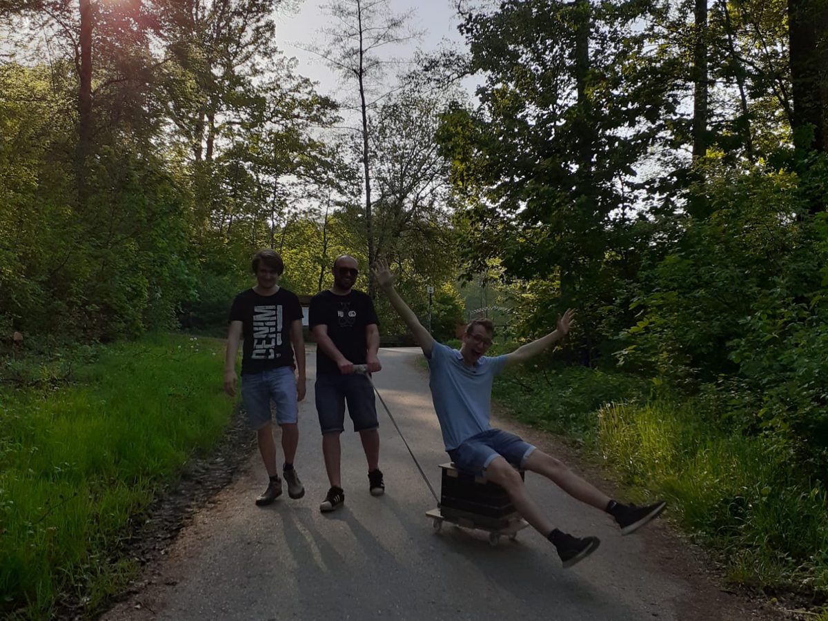 Jubelnd auf dem Bollerwagen im Gegenlicht