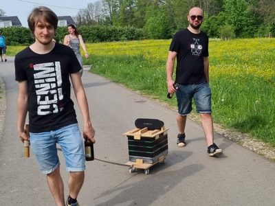 Ein Wanderer zieht den Bollerwagen mit dem Lautsprecher obendrauf