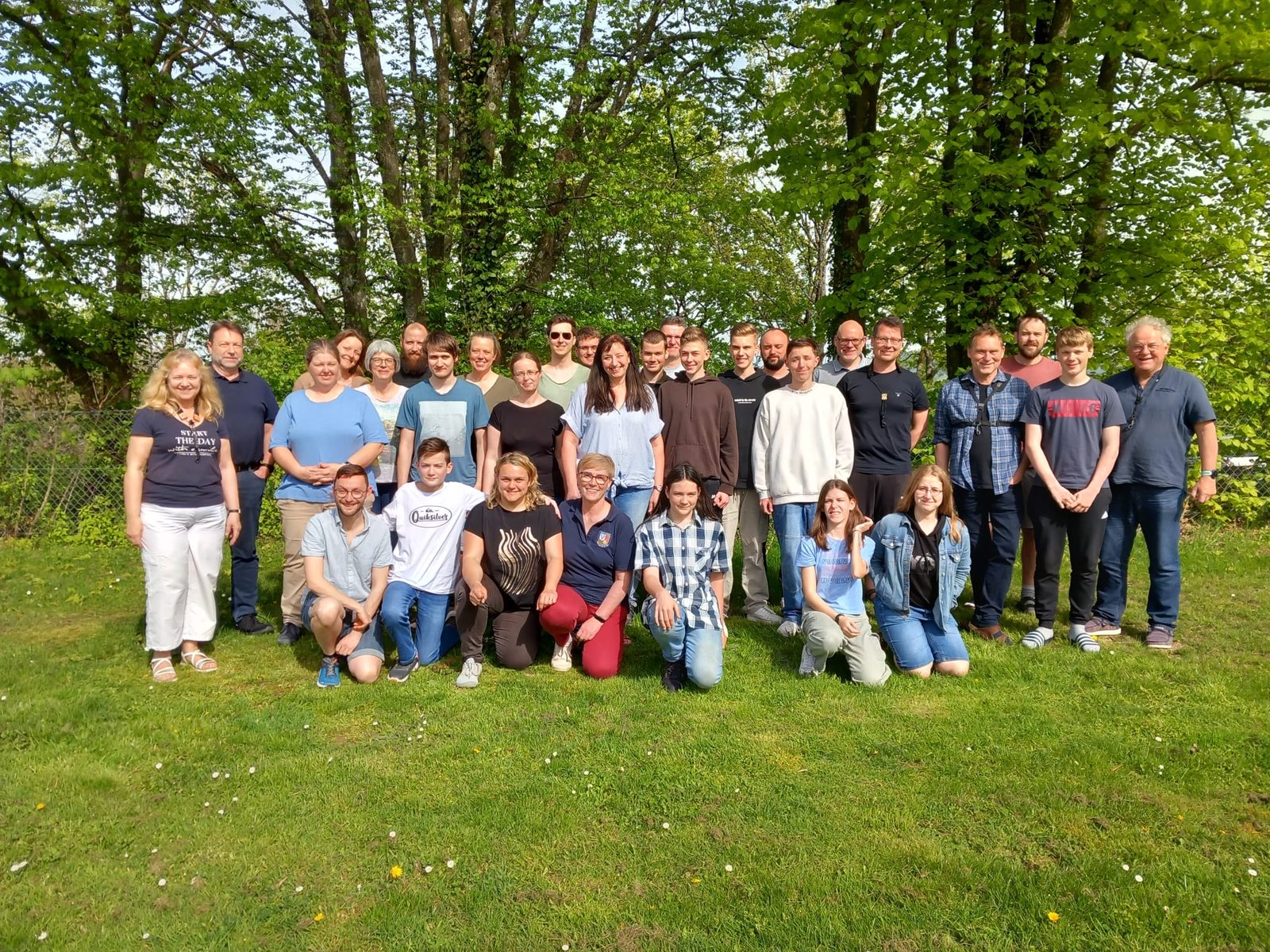 Gruppenbild der Musikerinnen und Musiker auf einer Wiese in der Frühlingssonne