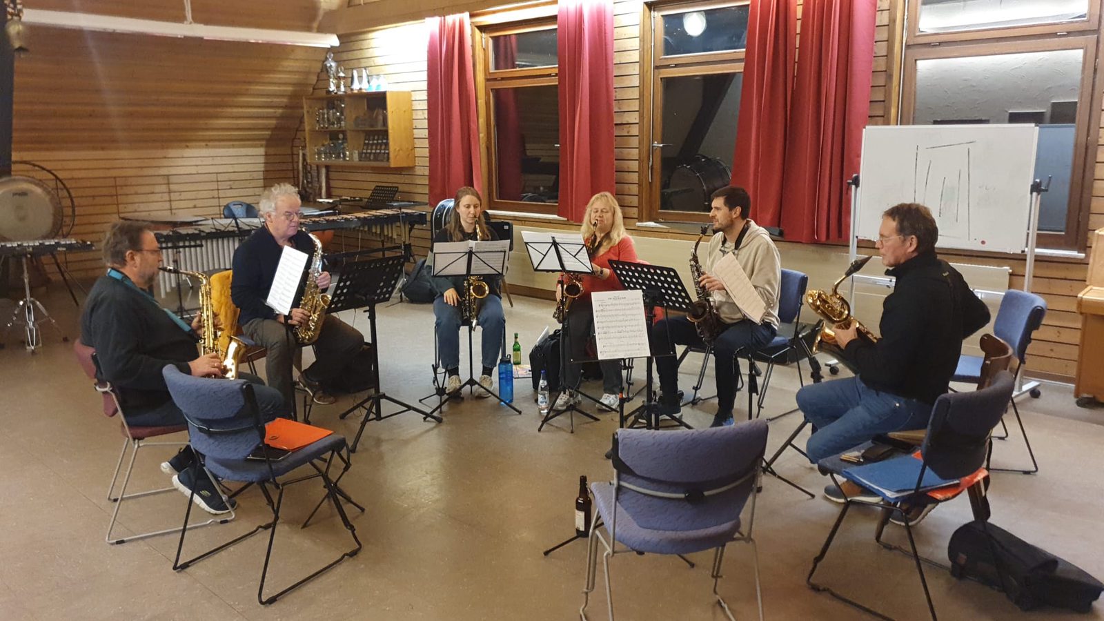 Sechs Saxophonistinnen und Saxophonisten proben im Kreis im Probelokal