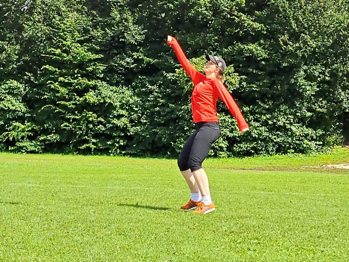 Eine Spielerin mit Kappe trifft den Ball mit der Faust