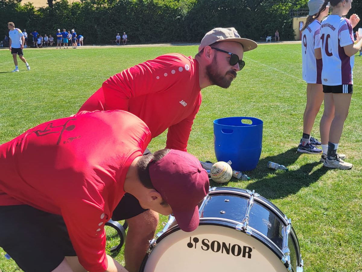 Zwei aus dem Team schlagen die große Trommel im Gras