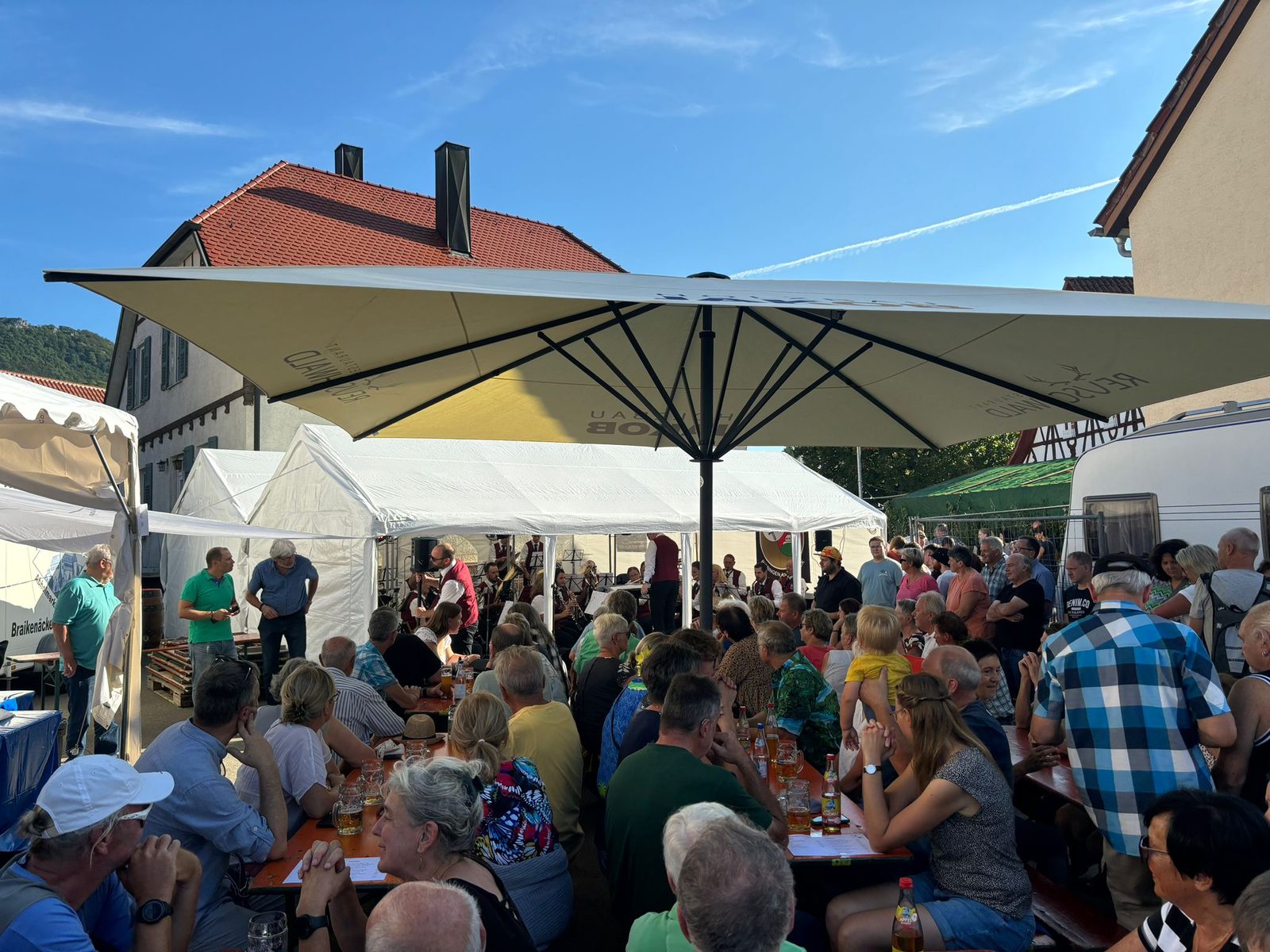 Der volle Kelterplatz unter blauem Himmel, hinten das Festzelt