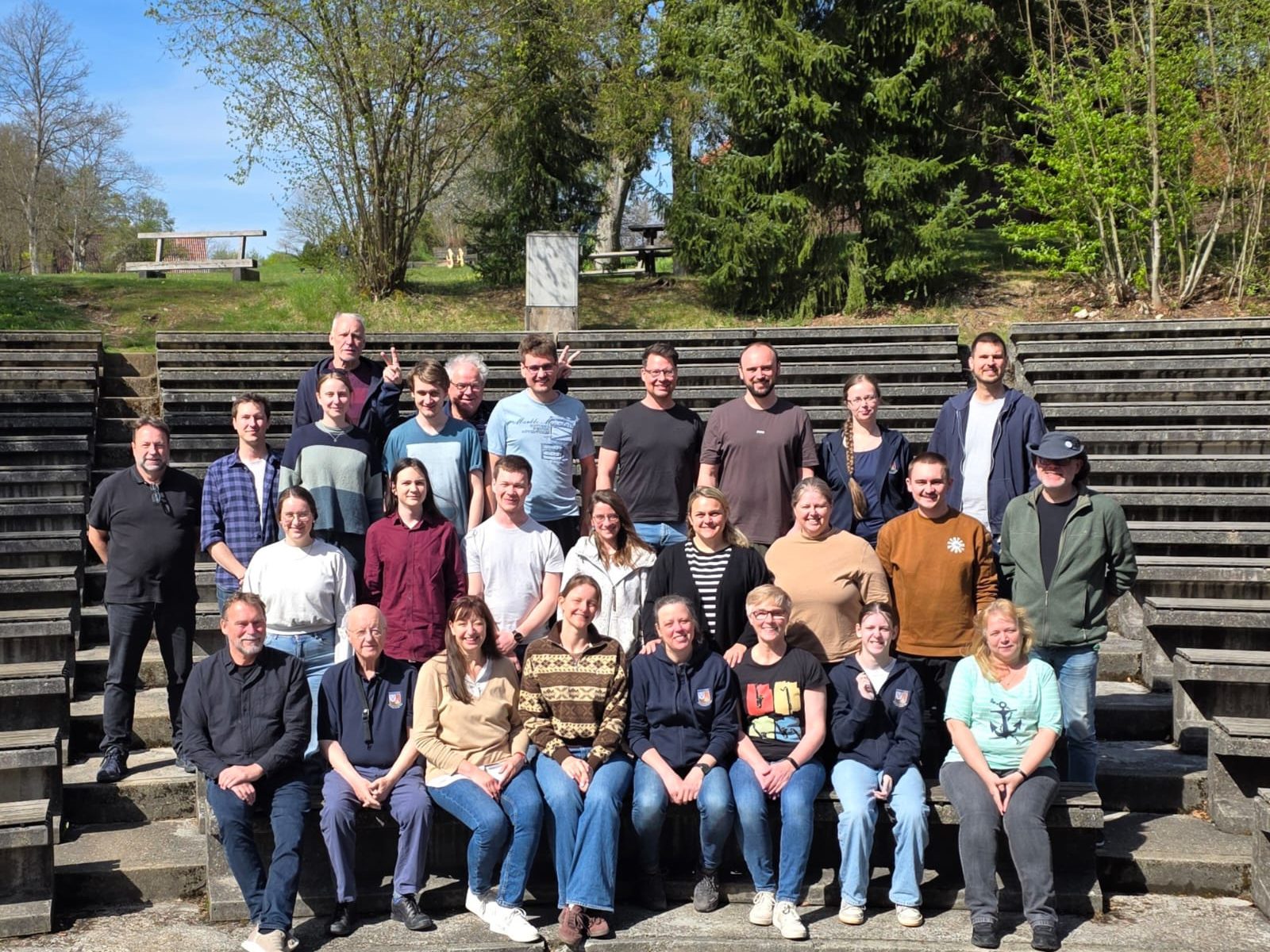 Gruppenbild der Stammkapelle auf den Stufen eines Freilufttheaters in der Sonne