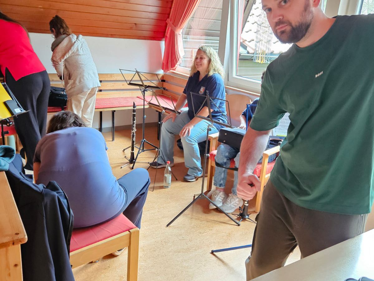 Ein Musiker schaut ganz ernst in die Kamera, dahinter die Klarinetten